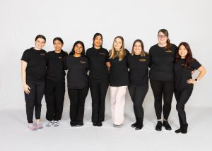 8 Female Team members stand together wearing dance ability black tshirts