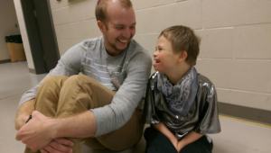 Cooper and a dancer smile at each other.