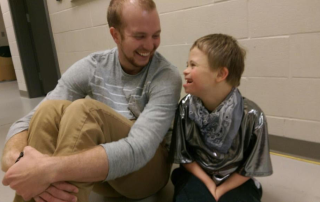 Cooper and a dancer smile at each other.